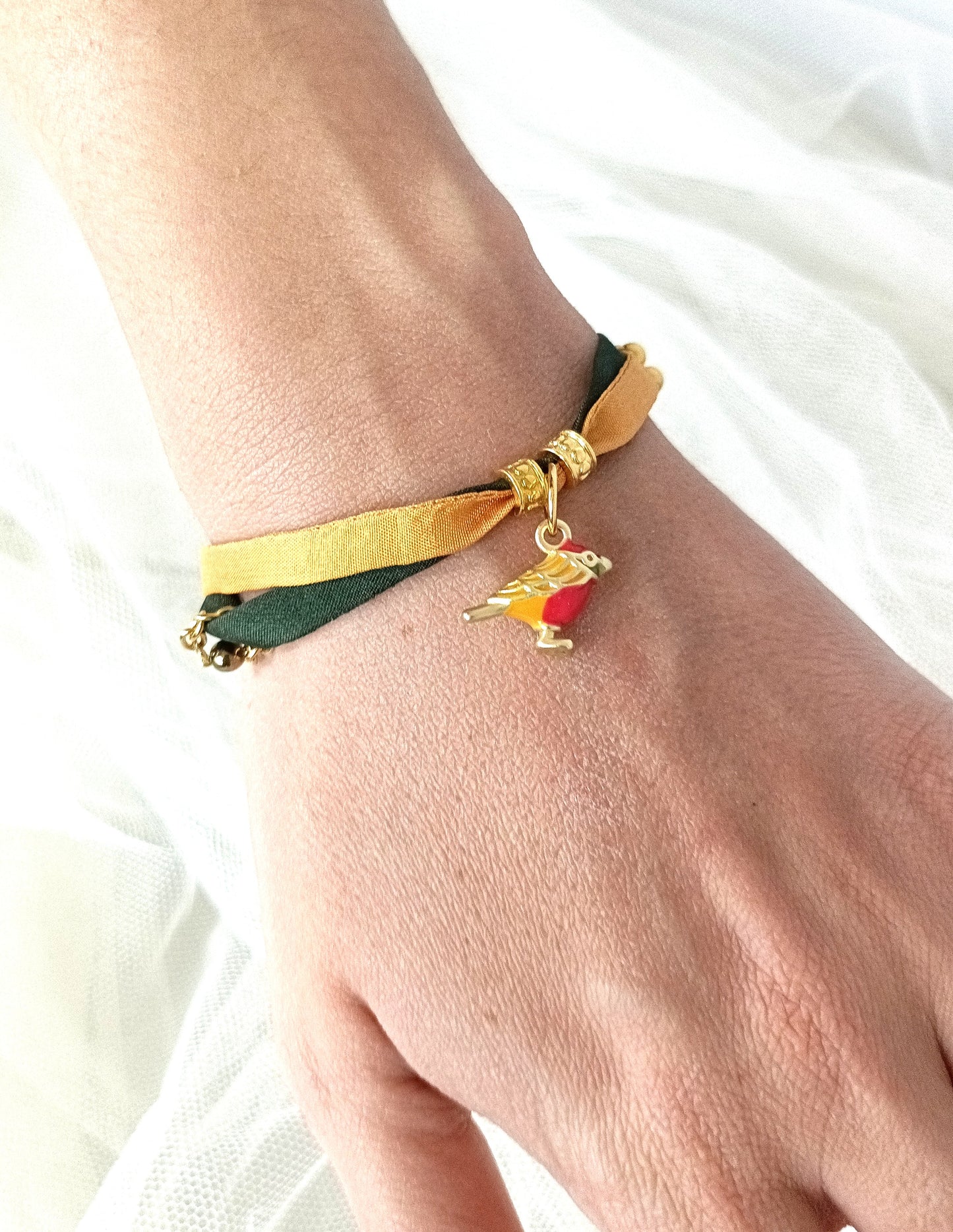 Pulsera de seda verde y mostaza con pajarita esmaltada