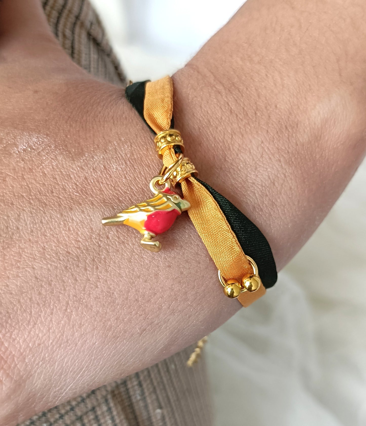 Pulsera de seda verde y mostaza con pajarita esmaltada