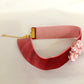 Choker rosa palo con detalle entrelazado.