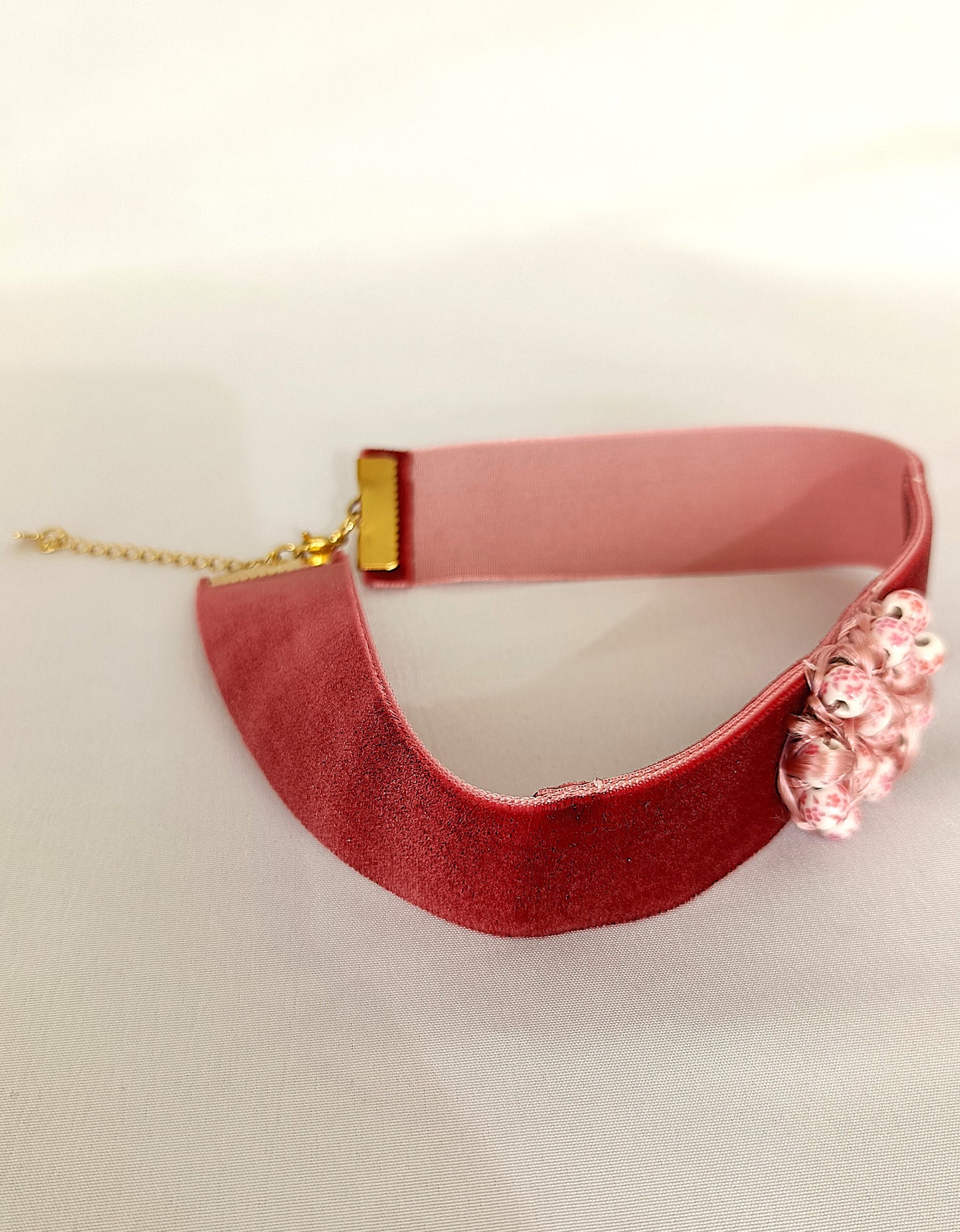 Choker rosa palo con detalle entrelazado.