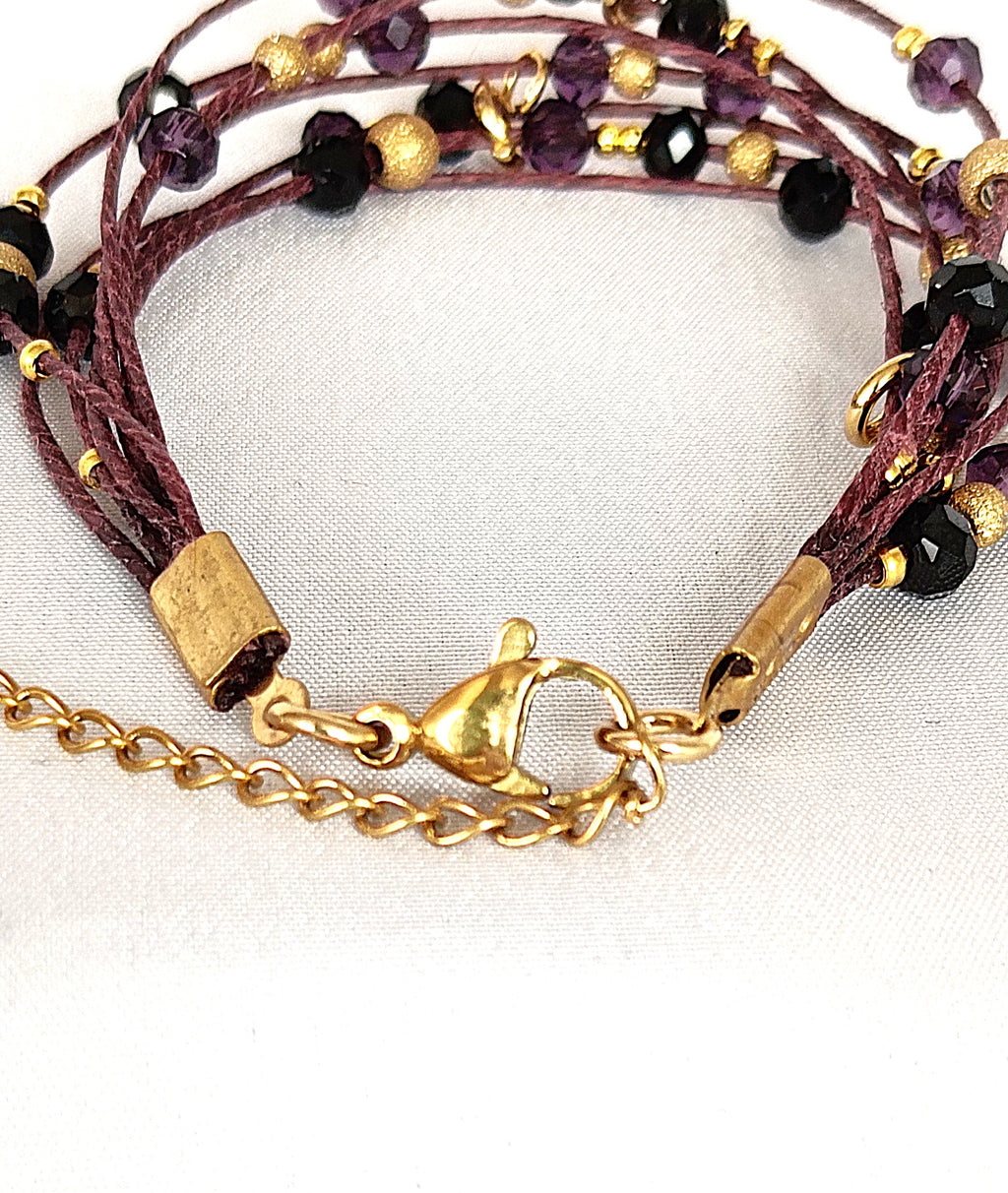 Pulsera granate de lino con cristal y acero dorado.