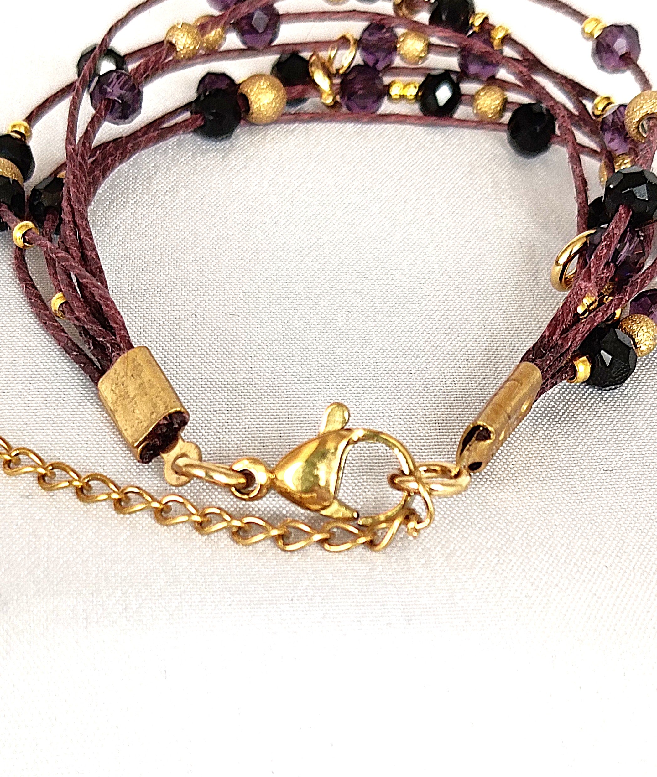 Pulsera granate de lino con cristal y acero dorado.