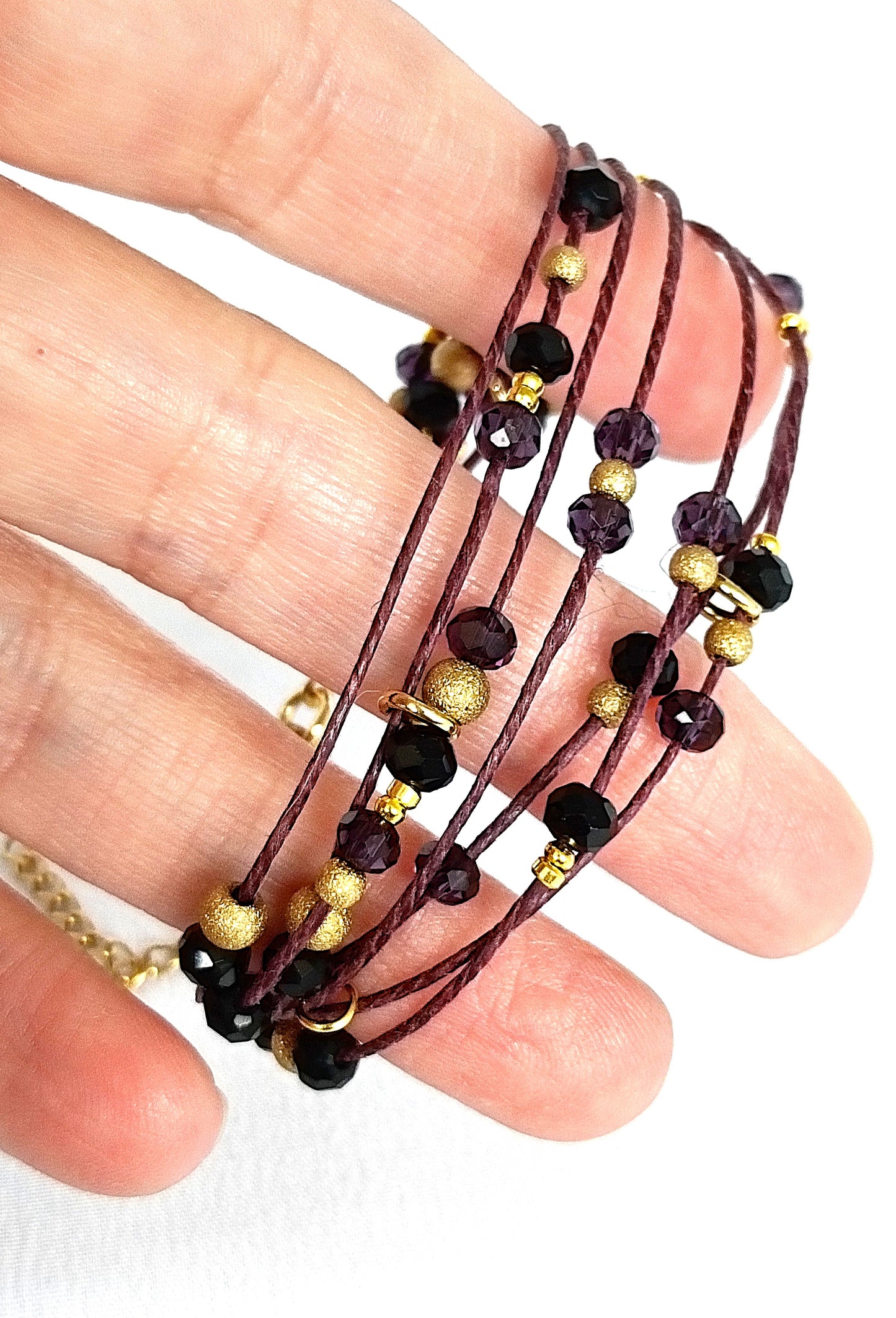 Pulsera granate de lino con cristal y acero dorado.