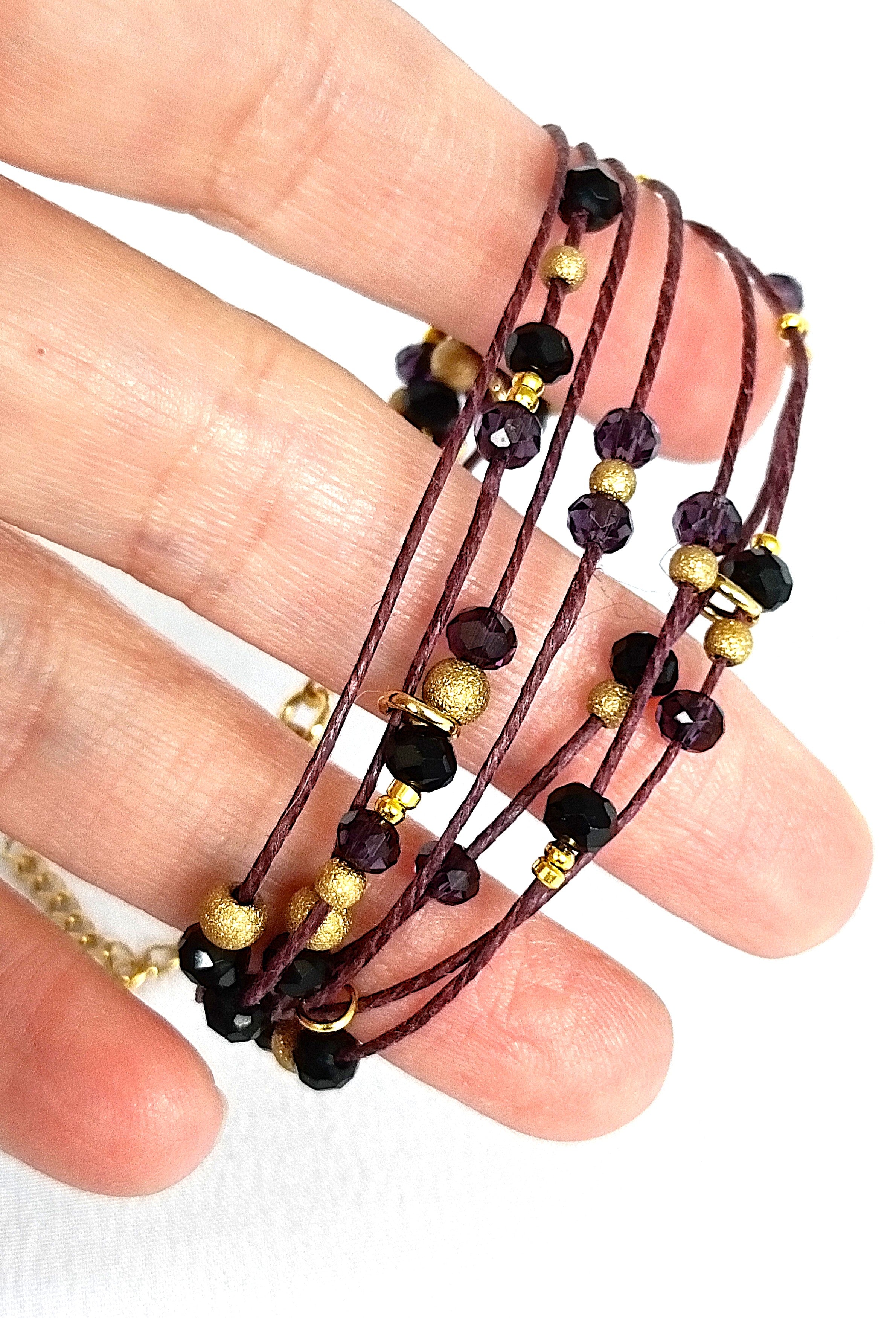 Pulsera granate de lino con cristal y acero dorado.