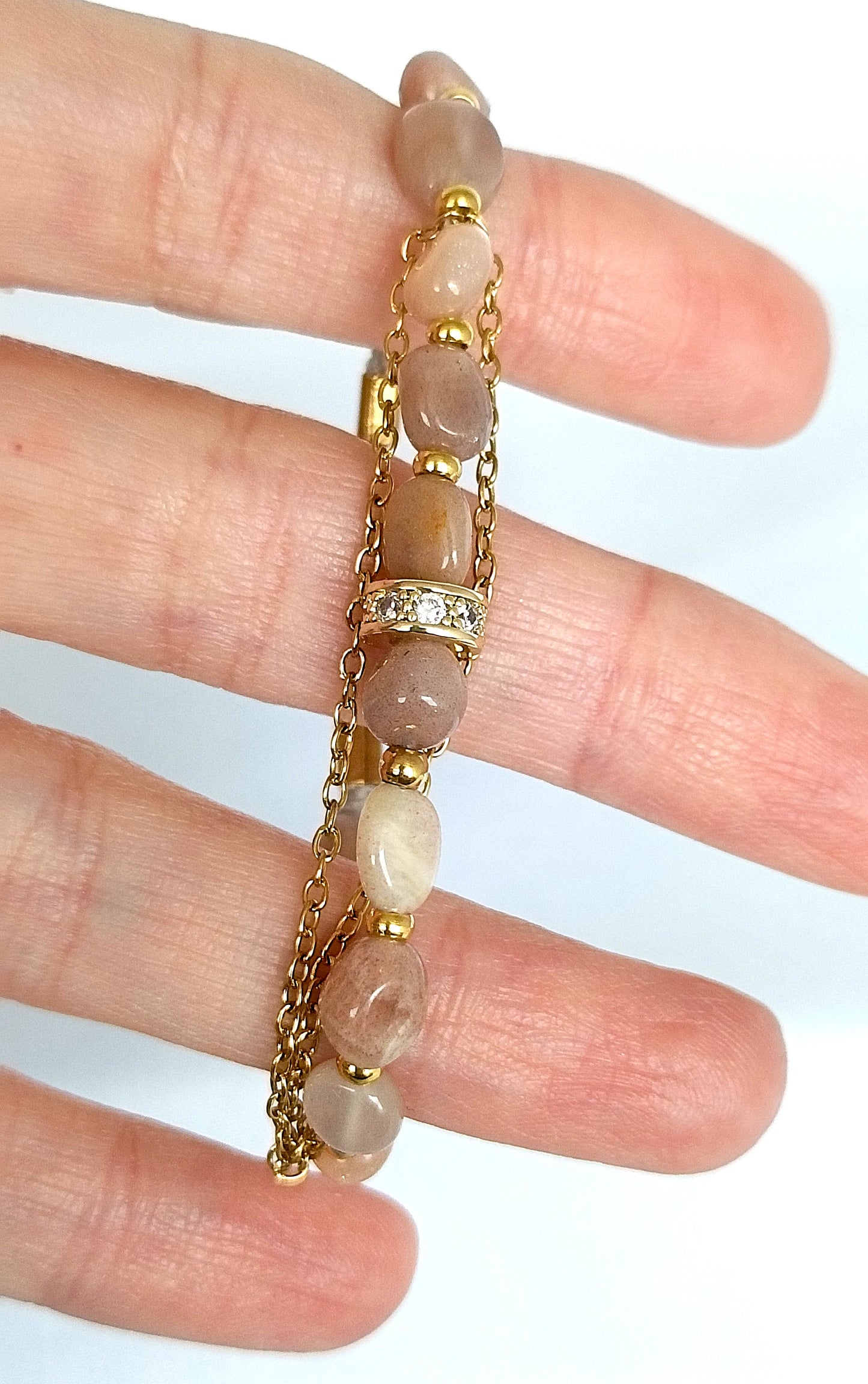 Pulsera de piedra del sol con cadenas doradas.