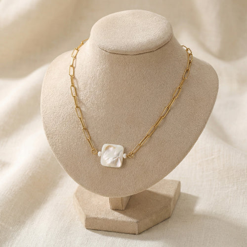 Cadena corta con cuentas de nácar blanco.
