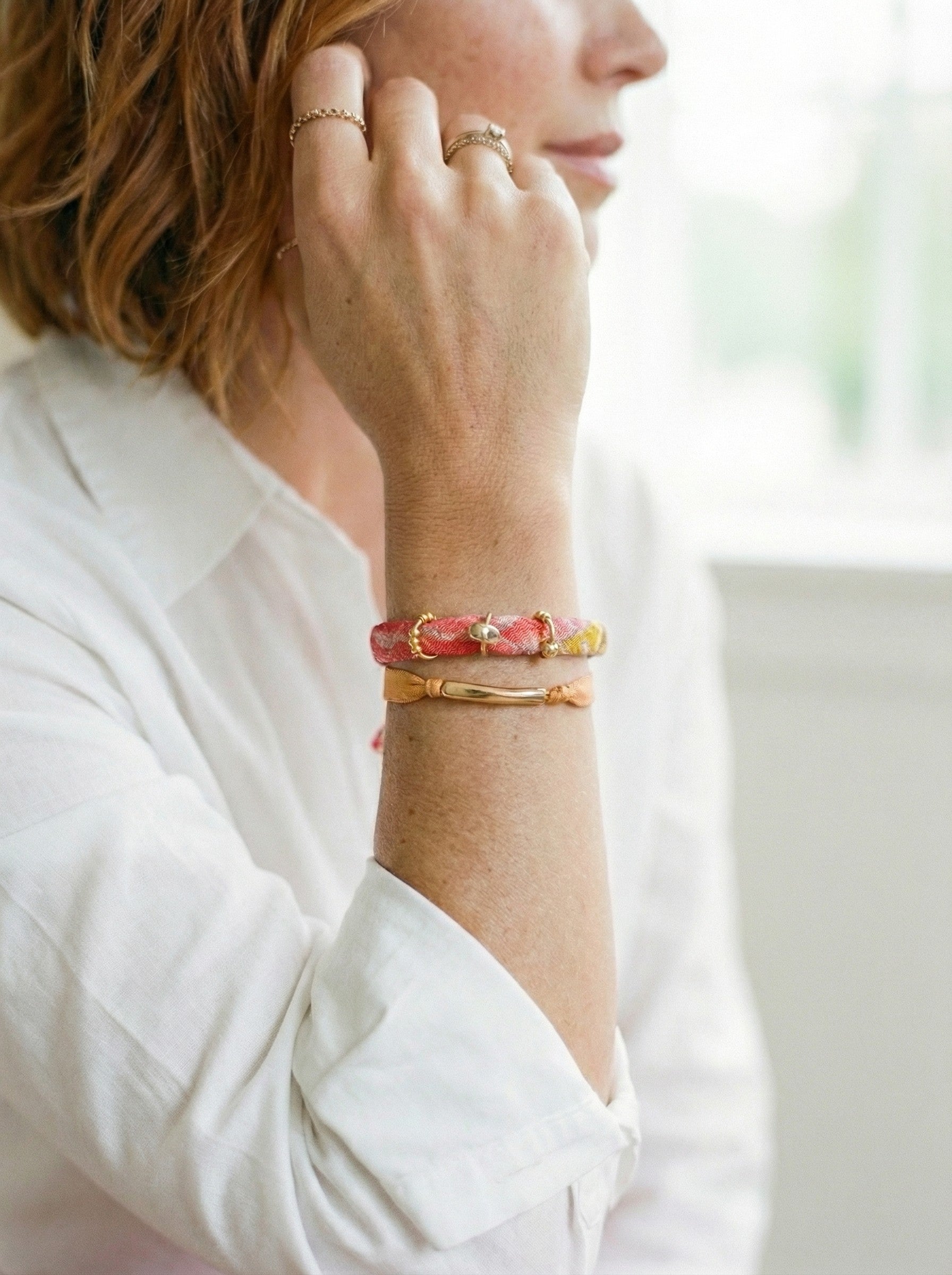 Pulsera doble de seda mostaza y cinta estampada con detalles dorados.