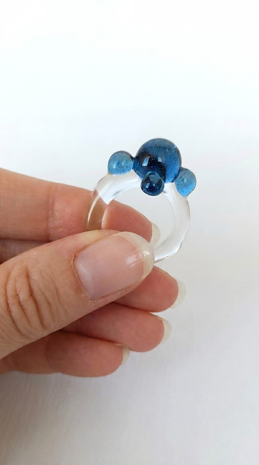 Anillo de vidrio de bolitas azules.