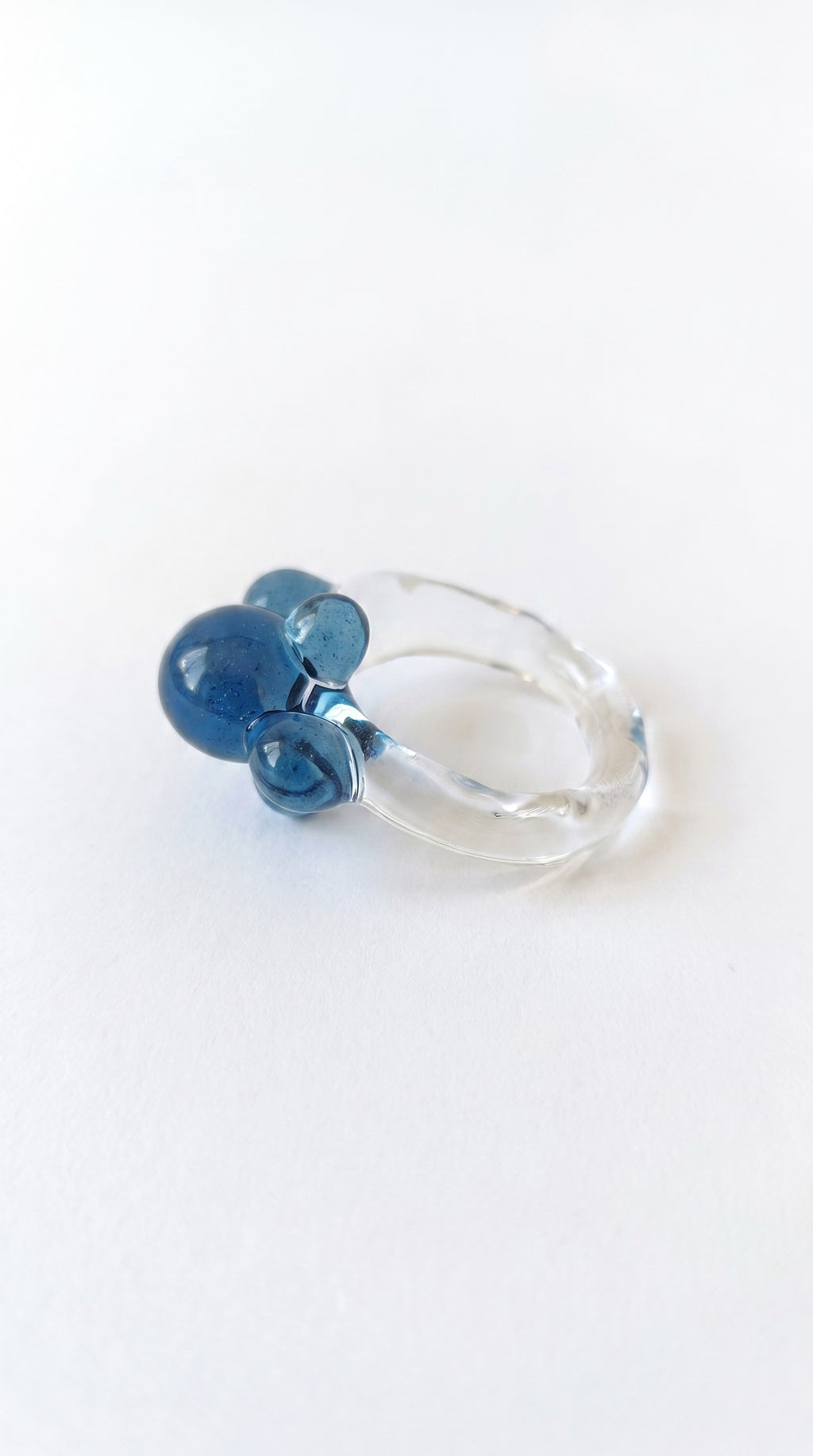 Anillo de vidrio de bolitas azules.