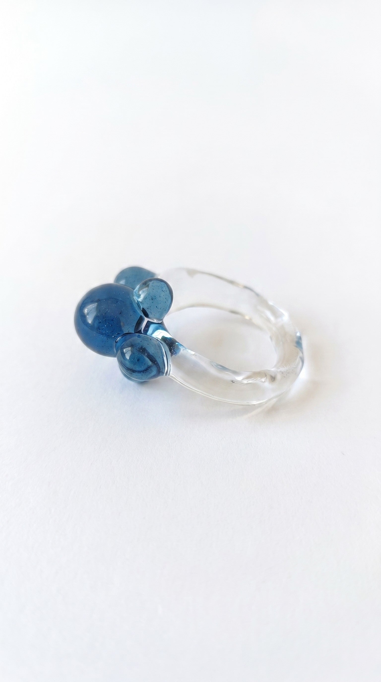 Anillo de vidrio de bolitas azules.