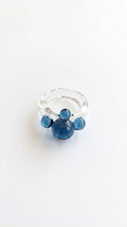 Anillo de vidrio de bolitas azules.