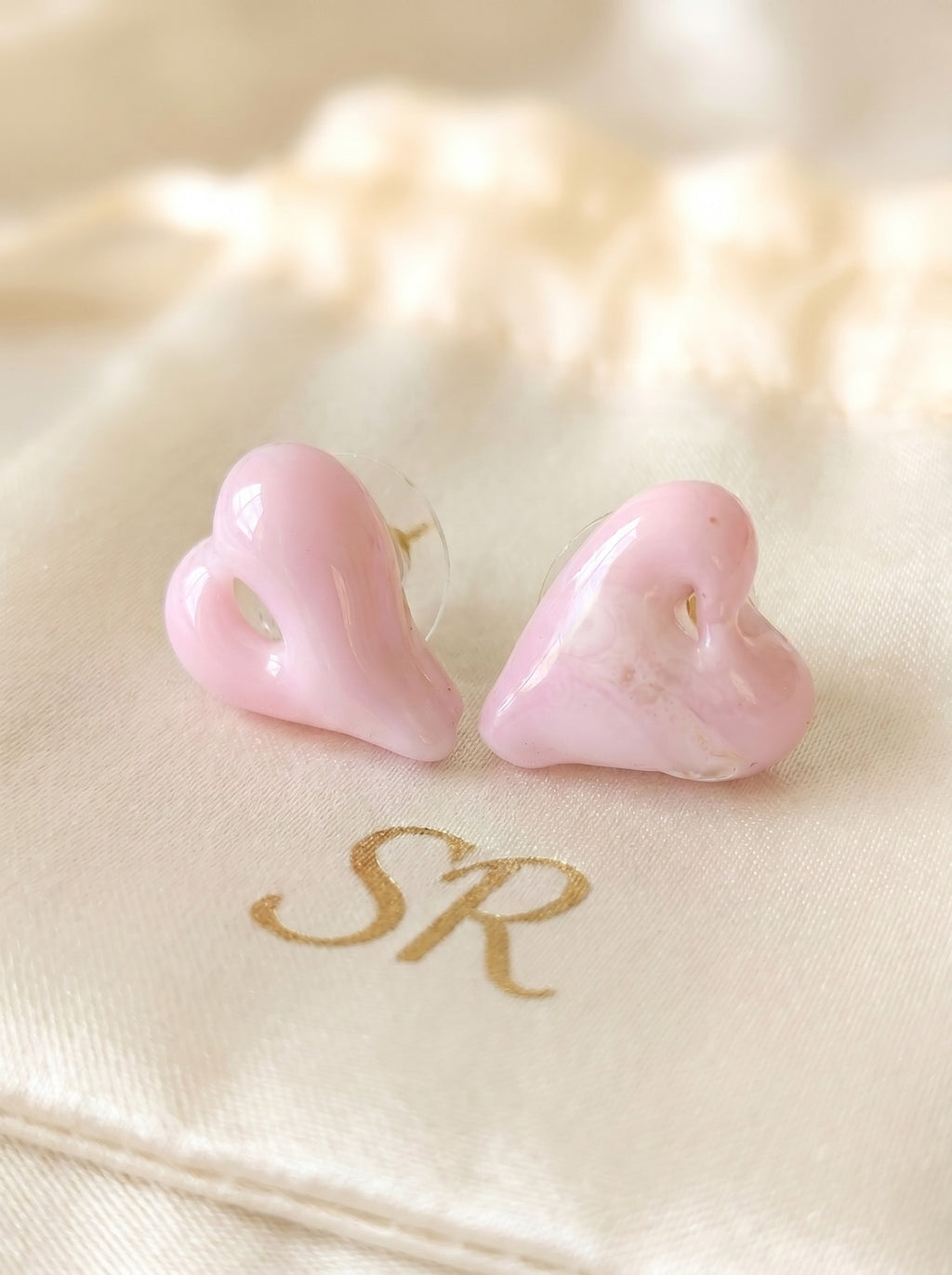 Pendientes de corazón rosa de vidrio.