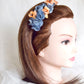 Diadema de flores de seda en azul y naranja, diseño elegante y romántico para invitada de boda o evento especial.