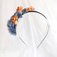 Diadema de flores de seda en azul y naranja, diseño elegante y romántico para invitada de boda o evento especial.
